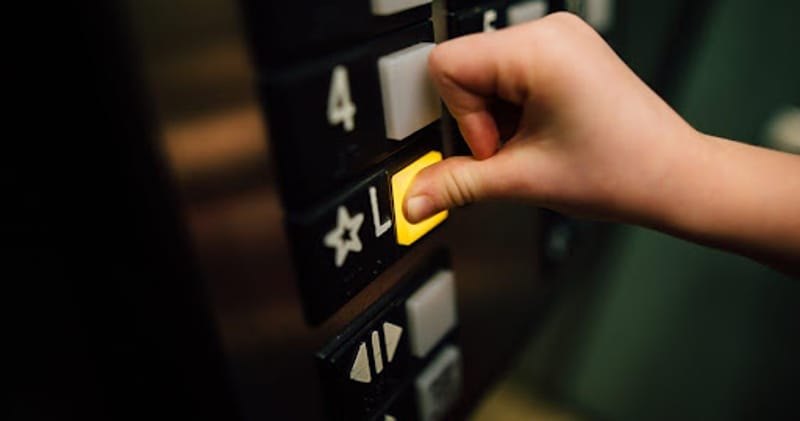 Person pushing elevator button