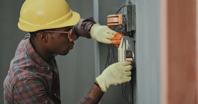 An Electrician Repairing a Fuse Box
