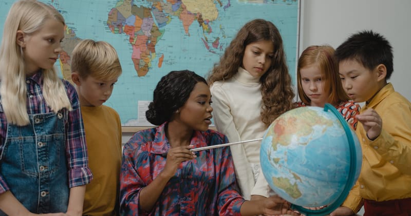 Teacher teaching students about Geography using a Globe
