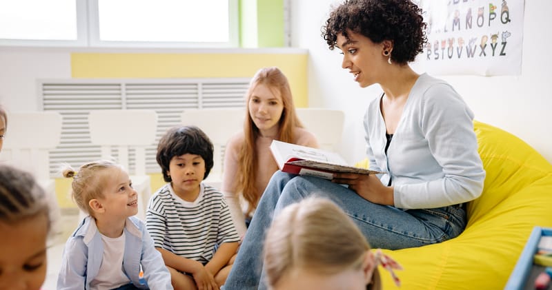 Woman Reading A Book To The Children

