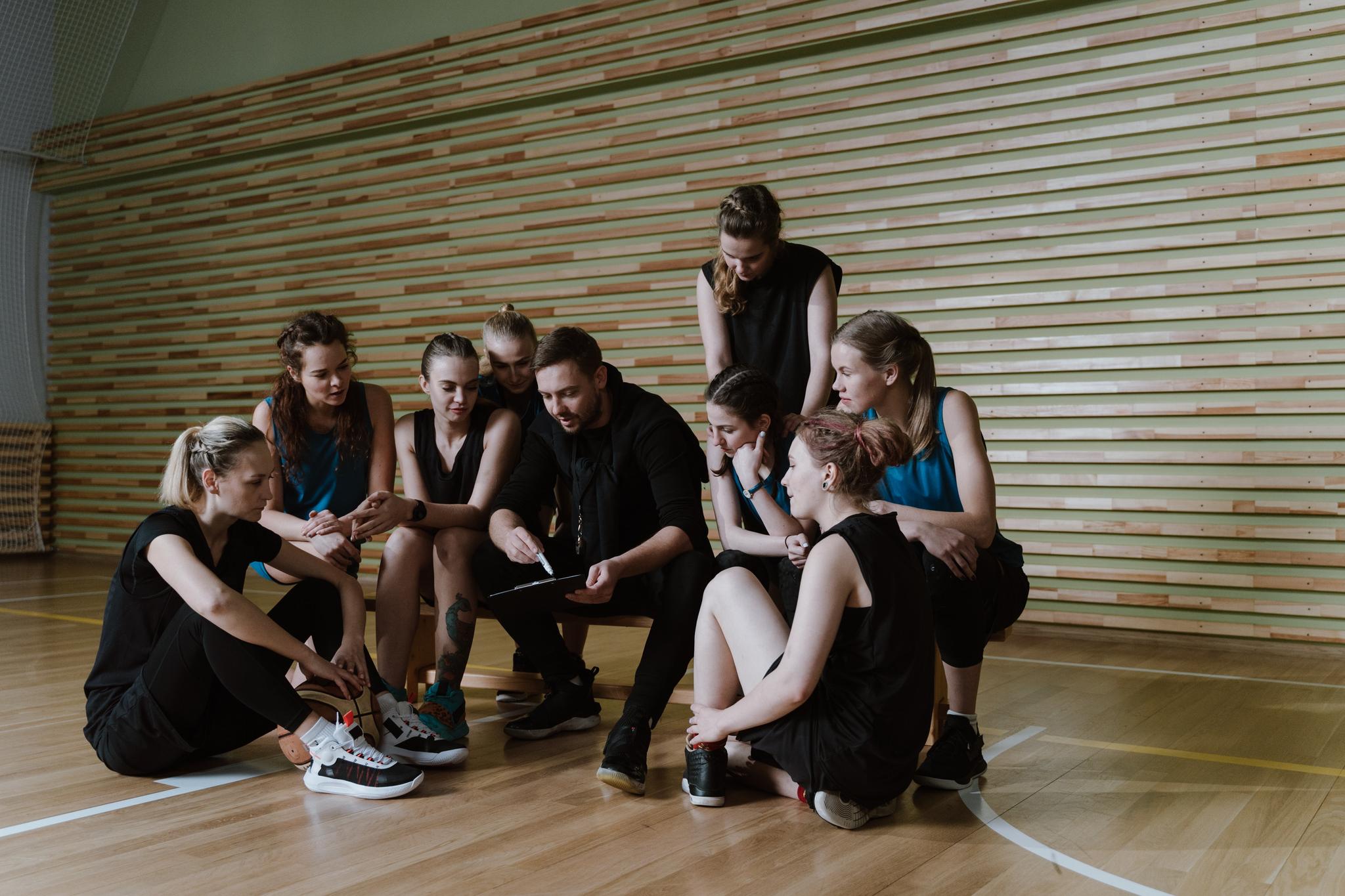 A Man Coaching a Team of Women