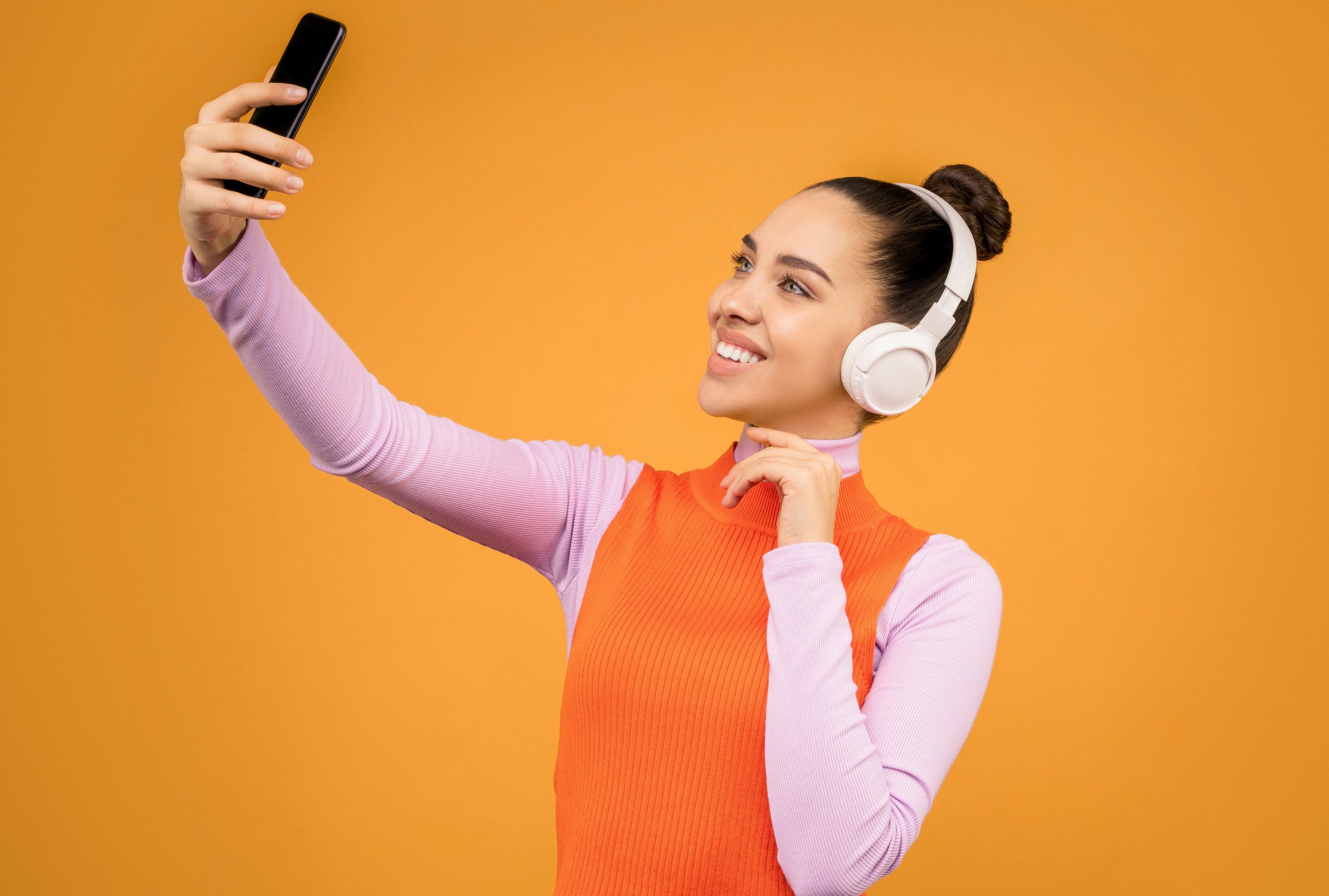 Woman in Knitted Long Sleeve Shirt Holding Black Mobile Phone