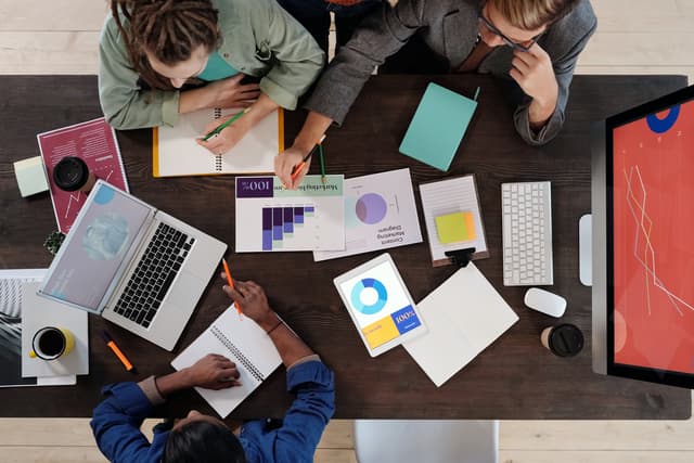 Overhead view of a team reviewing charts and laptops, from the data entry resume guide