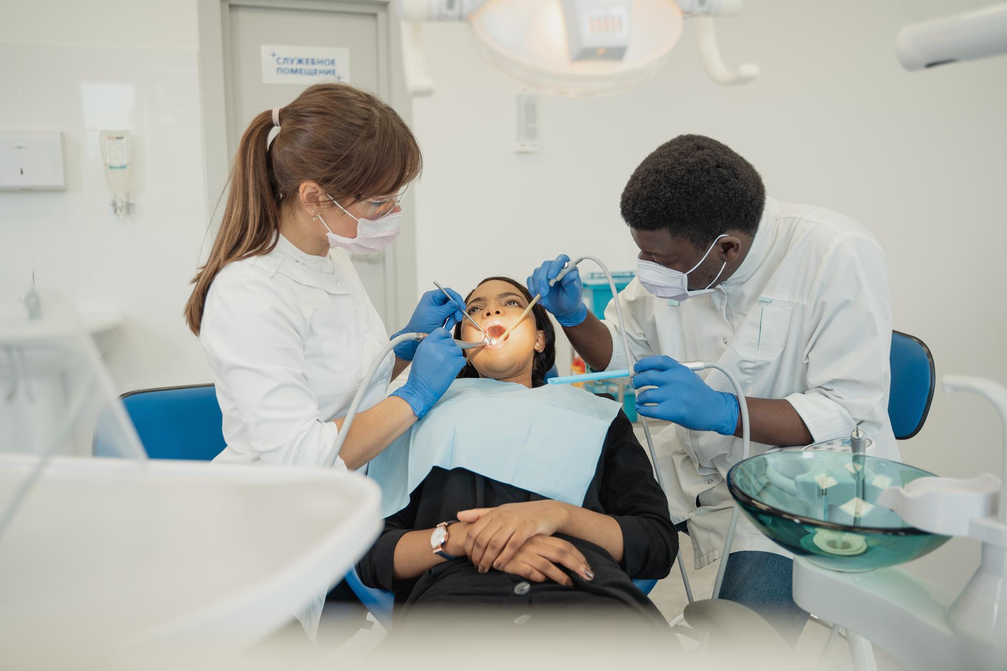 Two dental professionals treating a patient, from the dental assistant resume guide