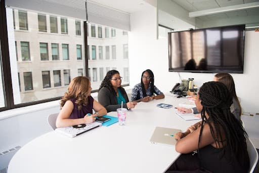 5 women talking at meeting table
