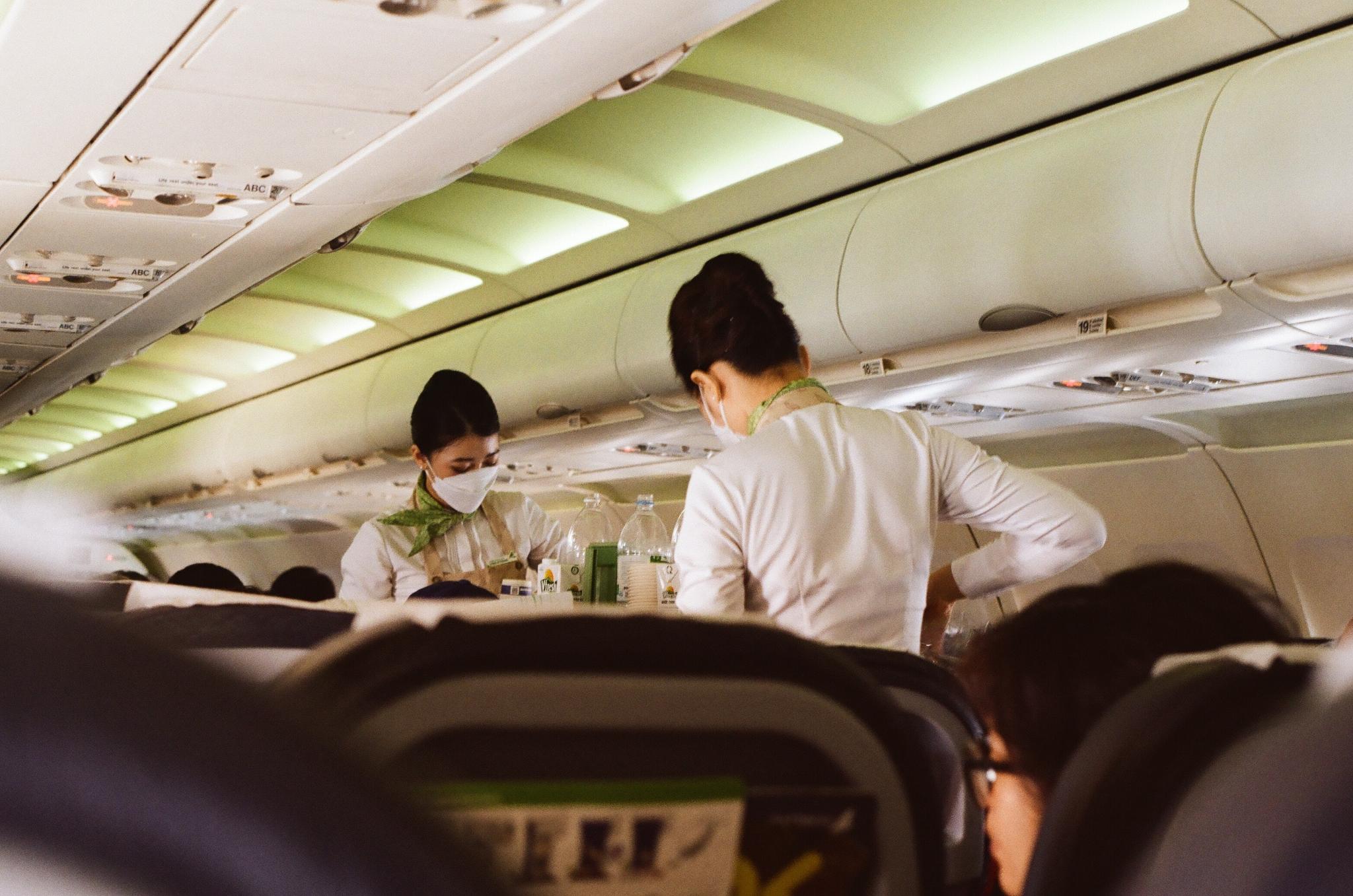 Flight attendants serving passengers in an airplane cabin