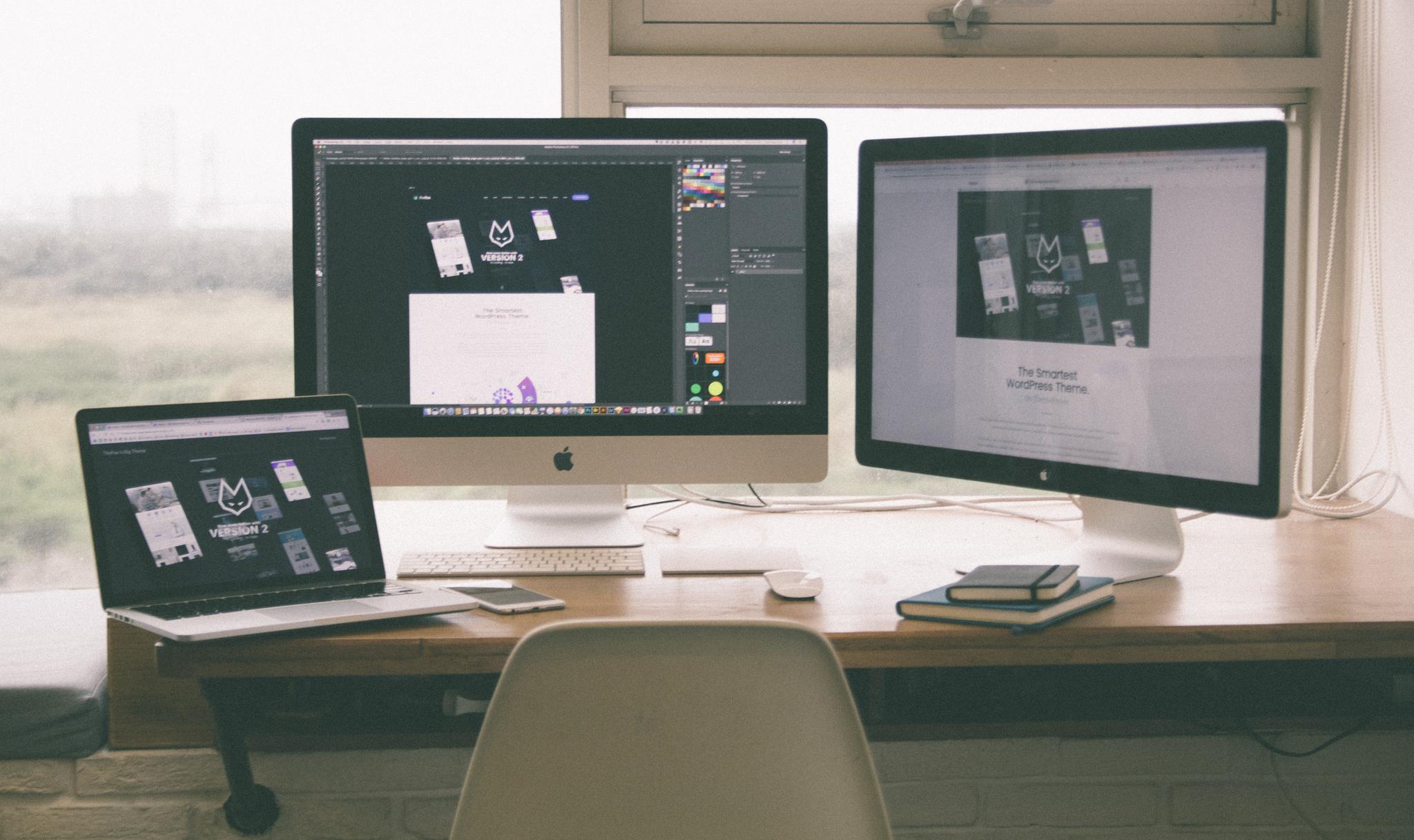 Designer workspace with three screens showing design projects, from the graphic designer resume guide