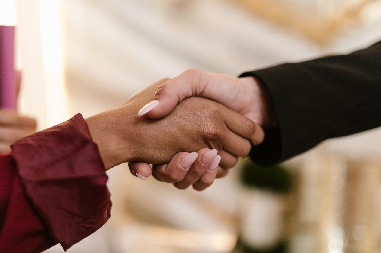 Close-up of two people shaking hands, from the guide to asking for a higher starting salary