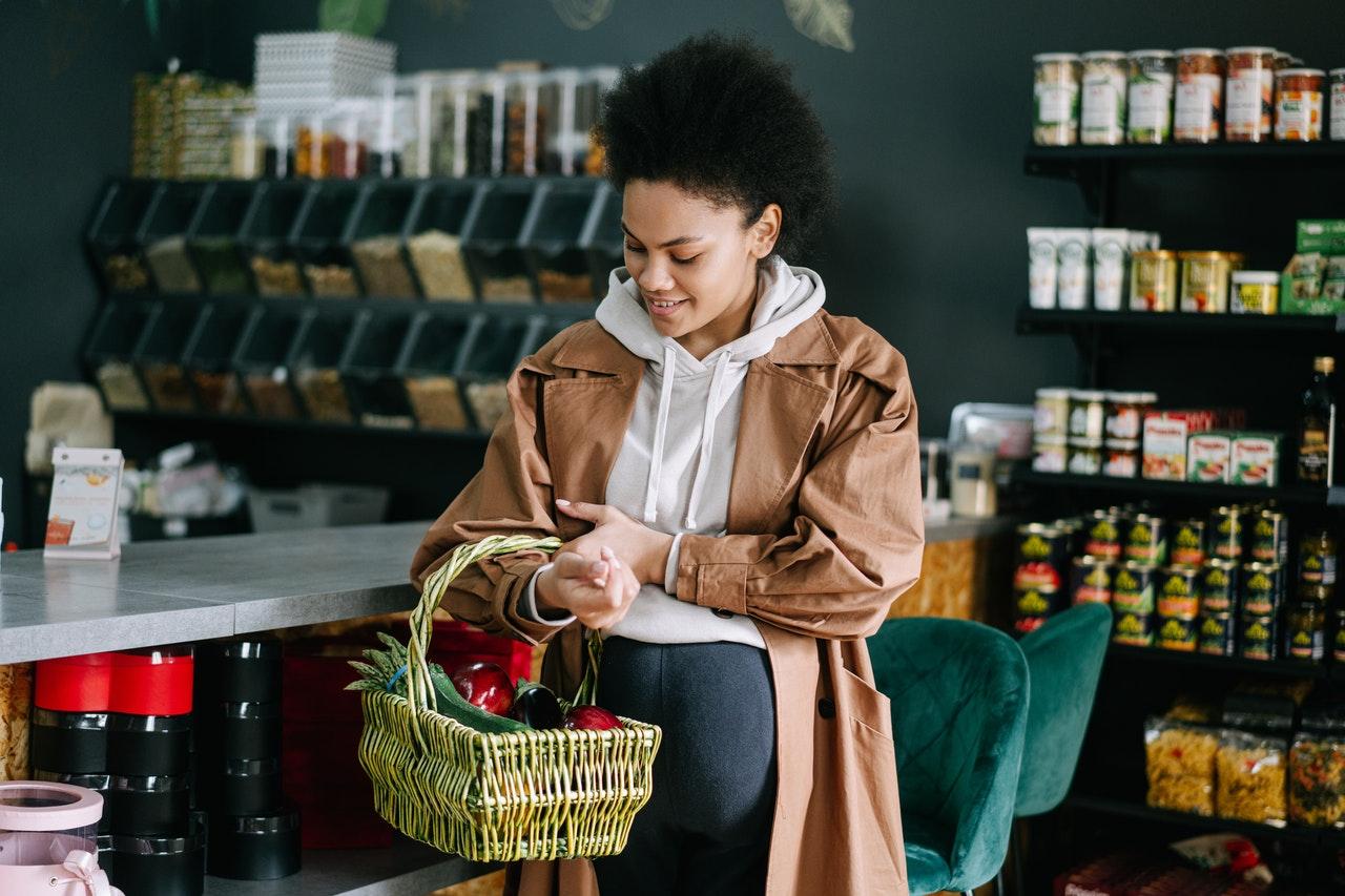 Shopper with a produce basket in a grocery store, from the guide to working for Instacart