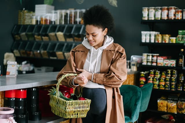 Shopper with a produce basket in a grocery store, from the guide to working for Instacart