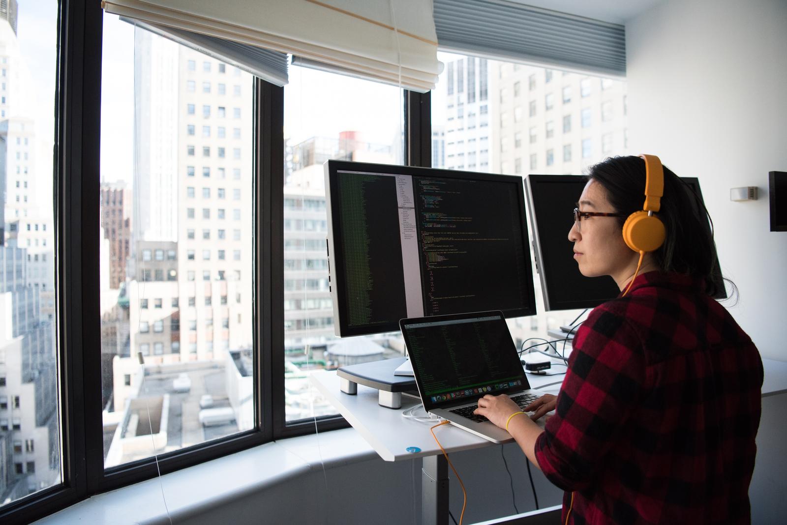 Woman standing While Operating Macbook Pro