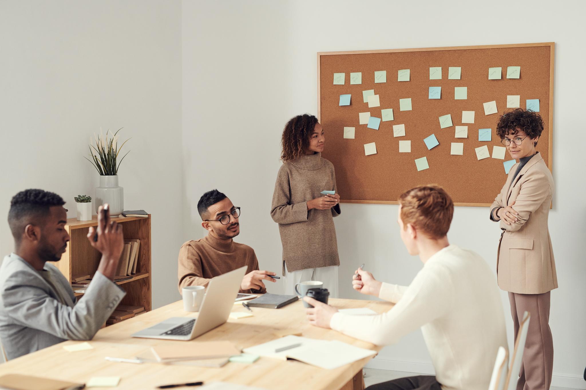Team brainstorming with sticky notes on a corkboard, from the scrum master resume guide