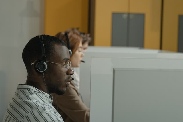 Man wearing a headset at a call center desk, from the transportation dispatcher salary guide
