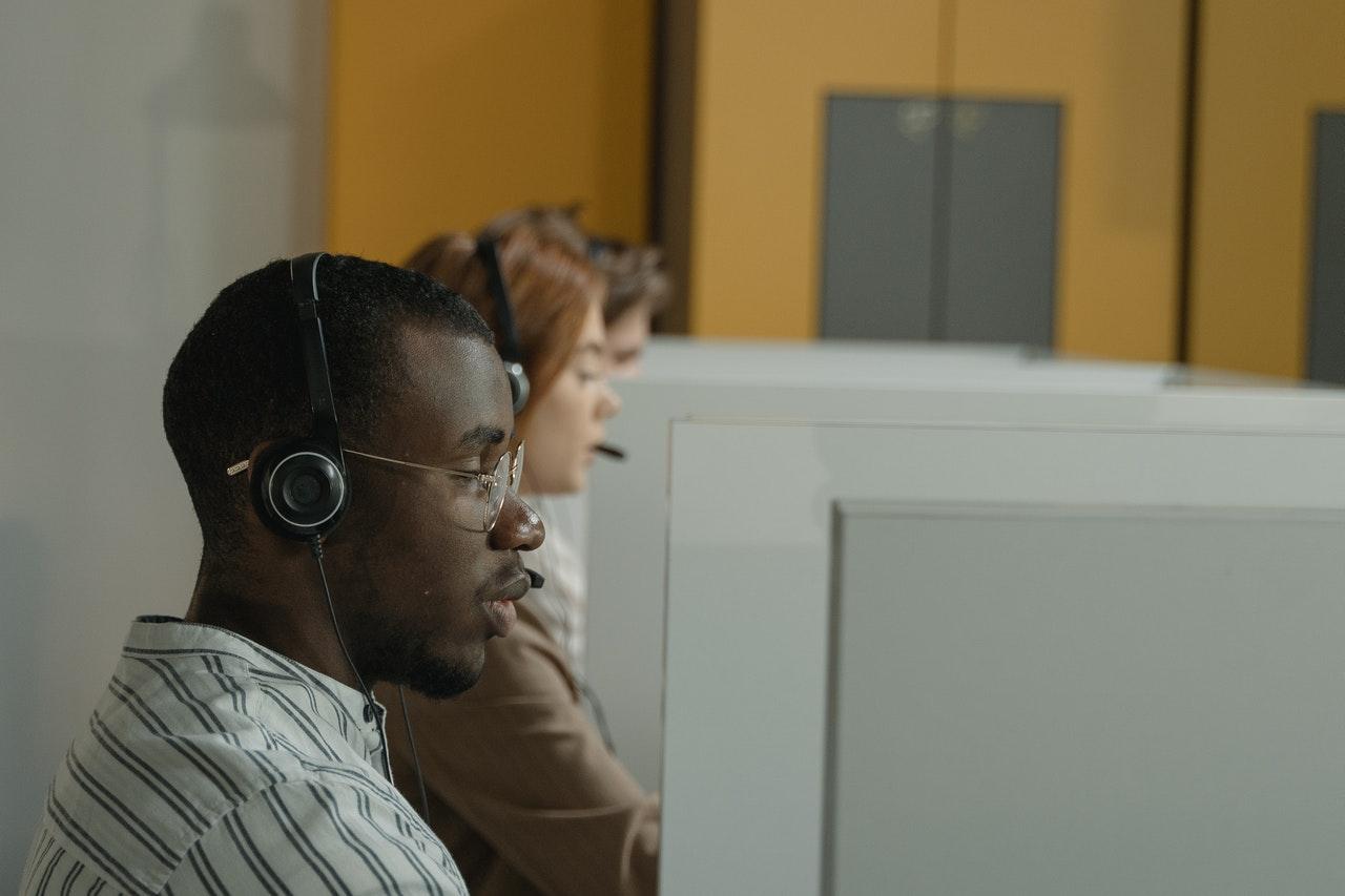 Man wearing a headset at a call center desk, from the transportation dispatcher salary guide